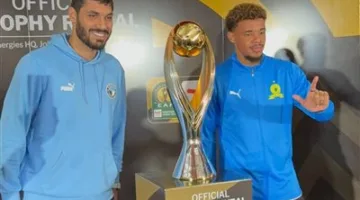 علي جبر من فريق بيراميدز وويليامز حارس صن داونز يتقاطعا صورة تذكارية مع الكأس الإفريقية بتصميمها الجديد