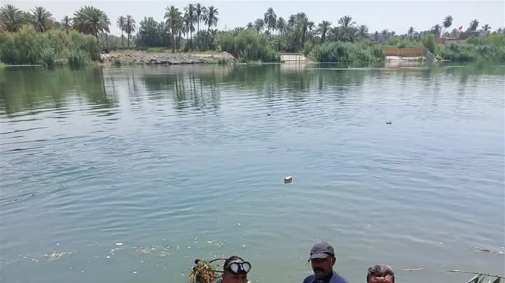 غواصو الشرطة في نهر الكوفة يستخرجون جثة شخص غارق.