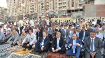 محافظ أسيوط participates in Eid al-Adha prayer at the sports grounds amidst large crowds.