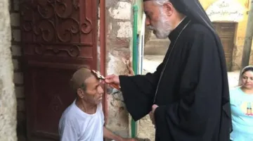 مطران الكاثوليك في المنيا يزور منازل رعية كنيسة السيدة العذراء في طوه | صور