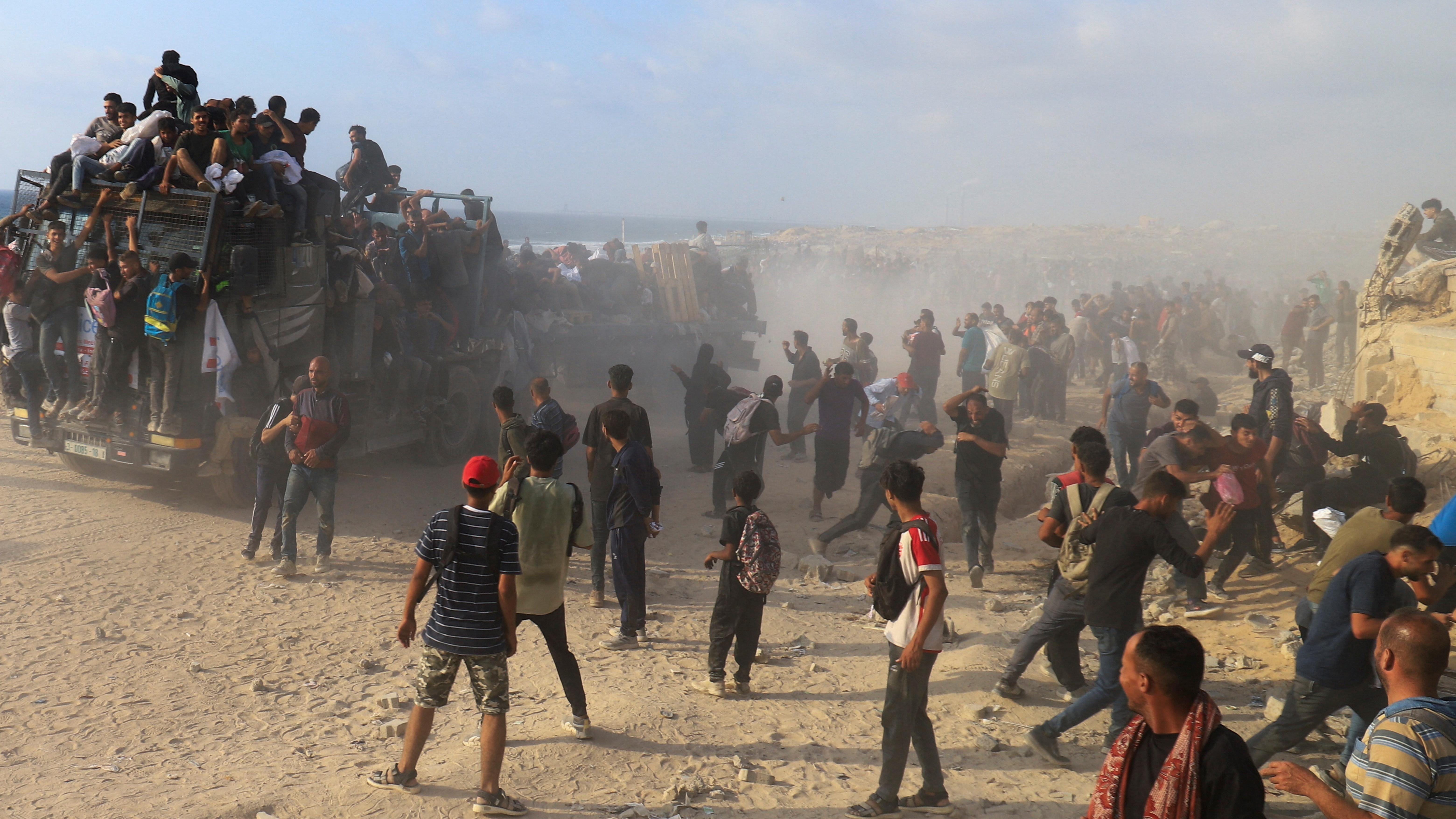 فلسطينيون يهرعون للحصول على مساعدات في بيت لاهيا شمالي قطاع غزة.