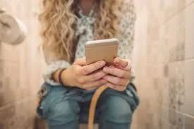 خطر قنبلة بكتيرية يهدد صحتك: احذر من استخدام هاتفك المحمول في الحمام