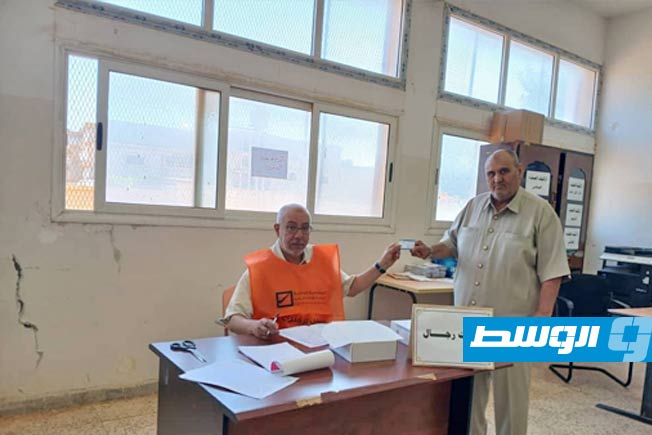 مواطن يتسلم بطاقته الانتخابية، 28 يونيو 2025. (مفوضية الانتخابات)