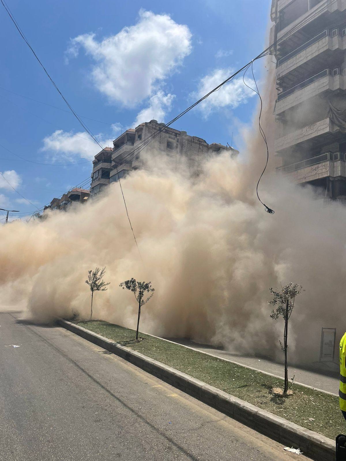 دخان كثيف جرّاء سقوط جزء من المبنى (الصورة عن صفحة اتحاد بلديات الضاحية).