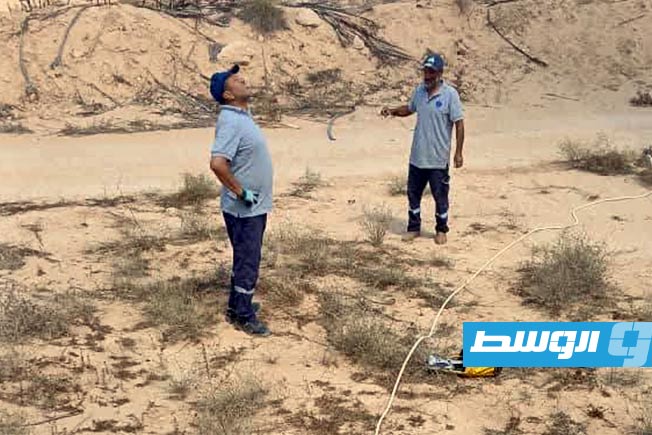 موظفان بشركة الكهرباء أثناء الصيانة الطارئة لدائرة نقل الطاقة غرب أجدابيا، 12 يوليو 2025 (الشركة العامة للكهرباء)