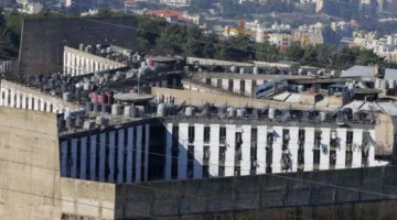 شخصان يقتربان من جدار المبنى… ما هو واقع هروب مسلحين من سجن رومية؟