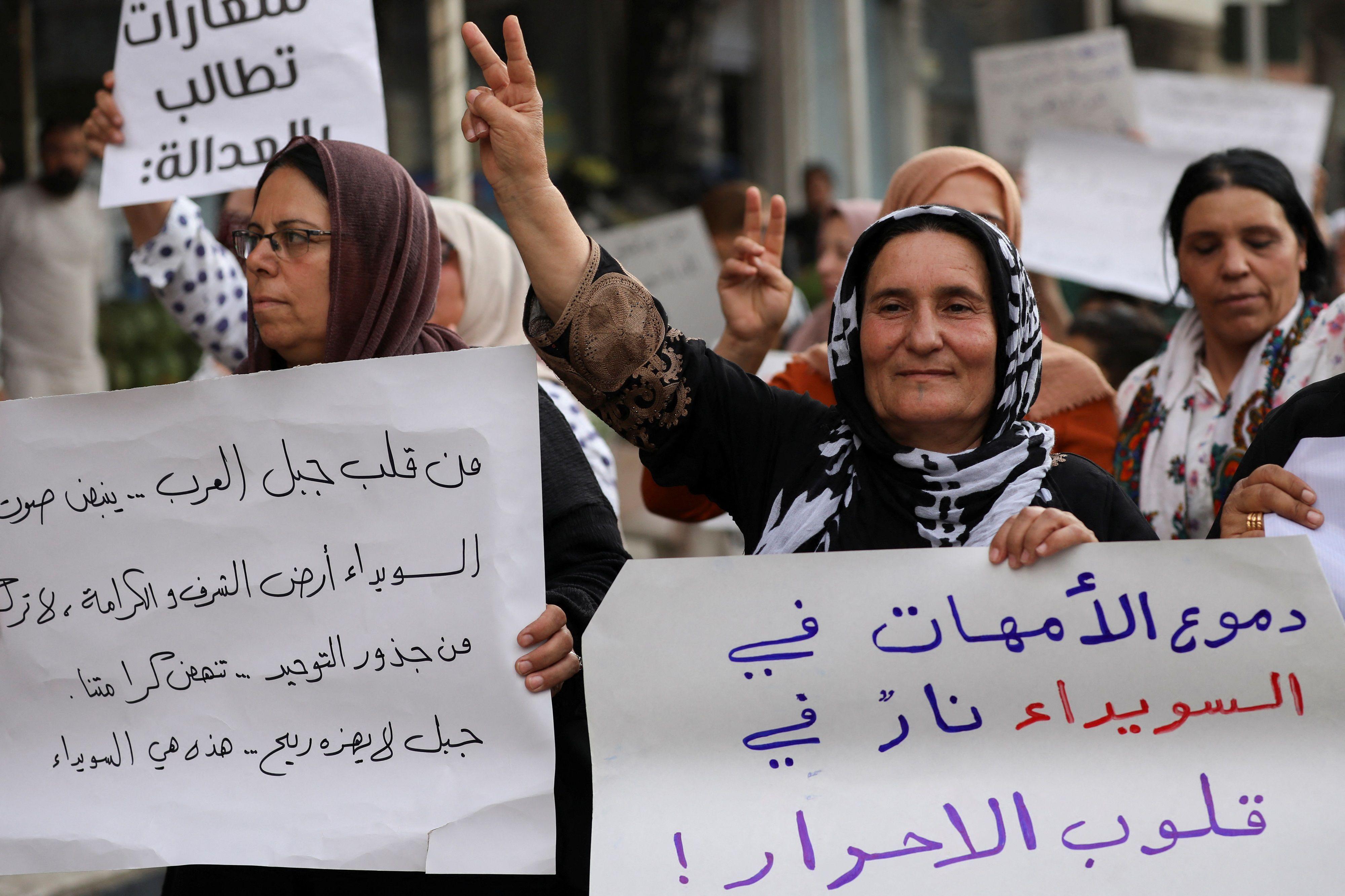 كرديات يشاركن في احتجاج تضامناً مع أهالي السويداء ويرفعن لافتات، إحداهن كُتب عليها "دموع الأمهات في السويداء نار في قلوب الأحرار".