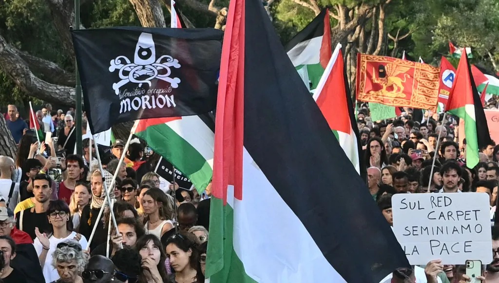 متظاهرون في مدينة البندقية أثناء مهرجانها السينمائي احتجاً على المجازر الإسرائيلية في فلسطين (أ ف ب)